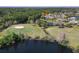 Picturesque aerial view of a golf course community home on the water with lush landscaping at 1432 Kinnard Cir, Ormond Beach, FL 32174