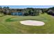 Golf course with a sand trap and pond in the distance, surrounded by trees and green grass at 1432 Kinnard Cir, Ormond Beach, FL 32174