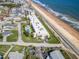 Aerial view showcasing a beachfront condo with a pool, lush landscaping, and proximity to the ocean at 2600 Ocean Shore Blvd # 103, Ormond Beach, FL 32176