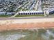 Aerial view of oceanfront condos with direct beach access and neighborhood in the background at 2600 Ocean Shore Blvd # 103, Ormond Beach, FL 32176