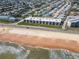 Aerial view of an oceanfront condo community with lush landscaping and views of the beach at 2600 Ocean Shore Blvd # 103, Ormond Beach, FL 32176