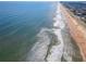 Beautiful aerial of the ocean and waves crashing on the sandy shoreline next to the road at 2600 Ocean Shore Blvd # 103, Ormond Beach, FL 32176