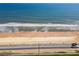 Expansive view of the sandy beach, blue ocean, and scenic highway of this coastal property at 2600 Ocean Shore Blvd # 103, Ormond Beach, FL 32176