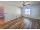 Bright bedroom featuring stylish ceiling fan, wood-look flooring and neighborhood views at 2600 Ocean Shore Blvd # 103, Ormond Beach, FL 32176