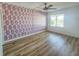 Bedroom features a ceiling fan, laminate floors and decorative accent wall at 2600 Ocean Shore Blvd # 103, Ormond Beach, FL 32176