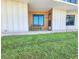 Cozy condo entrance with bench seating and inviting door, with green lawn at 2600 Ocean Shore Blvd # 103, Ormond Beach, FL 32176