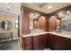 Elegant bathroom with dark wood cabinets, granite countertops, and double sinks at 3390 Ocean Shore Blvd # 4020, Ormond Beach, FL 32176
