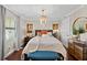 Bright bedroom with wooden floors, a chandelier, and pops of orange color throughout at 3390 Ocean Shore Blvd # 4020, Ormond Beach, FL 32176