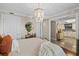 Bright bedroom featuring a decorative chandelier and a partial view of the kitchen at 3390 Ocean Shore Blvd # 4020, Ormond Beach, FL 32176