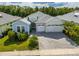 Charming single-story home showcasing a brick driveway, three-car garage, and lush landscaping at 753 Attitude Ave, Daytona Beach, FL 32124