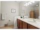 Bathroom featuring double sinks, wood cabinets, and a large mirror at 1320 Hansberry Ln, Ormond Beach, FL 32174