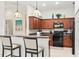 Traditional kitchen with wooden cabinets, breakfast bar, and modern appliances, including black oven and microwave at 1320 Hansberry Ln, Ormond Beach, FL 32174