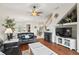 Open concept living room with dark sofas, hardwood floors, and a staircase at 1320 Hansberry Ln, Ormond Beach, FL 32174