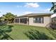 View of the backyard featuring a well-maintained lawn, a screened lanai, and privacy fencing at 187 Indian Wells Ave, Kissimmee, FL 34759