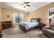 Cozy bedroom with a queen bed, ceiling fan, and a large window with a view at 187 Indian Wells Ave, Kissimmee, FL 34759