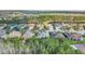 Community aerial showcasing homes nestled amidst lush trees and a peaceful lake at 187 Indian Wells Ave, Kissimmee, FL 34759