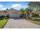 Paver driveway leads to a well-maintained single-story home with stone accents and a two-car garage at 187 Indian Wells Ave, Kissimmee, FL 34759