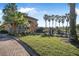 Neighborhood gate with palm trees, lush landscaping, and a paved brick road at 187 Indian Wells Ave, Kissimmee, FL 34759