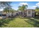 Attractive single-story home featuring a well-maintained lawn, palm trees, and colorful landscaping at 187 Indian Wells Ave, Kissimmee, FL 34759