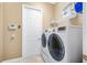 Laundry room with modern washer and dryer, shelving for supplies, and a clean, functional design at 187 Indian Wells Ave, Kissimmee, FL 34759