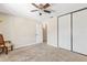 Neutral bedroom with plush carpet, a fan, closet, and a comfortable chair next to a window at 1 Tomoka Oaks Blvd # 112, Ormond Beach, FL 32174