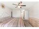 Bedroom with a ceiling fan, neutral walls, and a door that leads to an en-suite bathroom at 1 Tomoka Oaks Blvd # 112, Ormond Beach, FL 32174