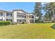 Exterior of a condominium community featuring well manicured lawns, a treed landscape, and ample parking at 1 Tomoka Oaks Blvd # 112, Ormond Beach, FL 32174