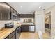 Modern kitchen showcasing stainless steel appliances, dark cabinets, and a tiled floor at 1 Tomoka Oaks Blvd # 112, Ormond Beach, FL 32174