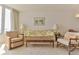 Bright living room featuring a floral sofa, wooden coffee table, and ocean views through a large window at 1133 Ocean Shore Blvd # 302, Ormond Beach, FL 32176