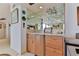 Stylish bar area with mirrored backsplash, glass shelving, and wooden cabinetry at 1133 Ocean Shore Blvd # 303, Ormond Beach, FL 32176