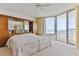 Bright bedroom with ocean views, sliding glass doors to balcony, and built in shelving at 1133 Ocean Shore Blvd # 303, Ormond Beach, FL 32176