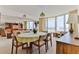 Bright dining room featuring an oval table, six chairs, and ocean views through large windows and sliding doors at 1133 Ocean Shore Blvd # 303, Ormond Beach, FL 32176