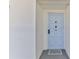 Hallway view of unit 303, showing the entrance door with a light blue finish and neutral carpet at 1133 Ocean Shore Blvd # 303, Ormond Beach, FL 32176