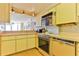 Kitchen with yellow cabinets and retro appliances at 1133 Ocean Shore Blvd # 303, Ormond Beach, FL 32176