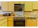 A kitchen with yellow cabinets and retro appliances at 1133 Ocean Shore Blvd # 303, Ormond Beach, FL 32176