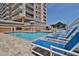 Outdoor pool with lounge chairs, set against the backdrop of a high-rise condo building at 1425 Ocean Shore Blvd # 102, Ormond Beach, FL 32176