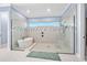 A contemporary bathroom features a glass shower and soaking tub separated with decorative tile and a neutral color palette at 2244 S Halifax Dr, Daytona Beach, FL 32118