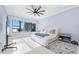 The main bedroom features light blue walls, wood-look tile flooring, a ceiling fan, and a large window overlooking the water at 2244 S Halifax Dr, Daytona Beach, FL 32118