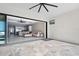 Open patio with light stone floor tile leading into a stylish living area with ceiling fan and sliding glass doors at 2244 S Halifax Dr, Daytona Beach, FL 32118