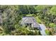 An aerial view shows the beautiful home with a screened-in pool and a paved driveway surrounded by lush landscaping at 2337 Legacy Ln, New Smyrna Beach, FL 32168