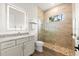 Modern bathroom showcasing a walk-in shower with pebble flooring and a granite countertop vanity with an LED mirror at 2337 Legacy Ln, New Smyrna Beach, FL 32168