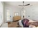 Bright bedroom featuring a ceiling fan, wood floors, a dresser with a mirror, and an exterior door at 2337 Legacy Ln, New Smyrna Beach, FL 32168