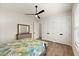 Bright bedroom featuring a ceiling fan, wood floors, a dresser with a mirror, and ample closet space at 2337 Legacy Ln, New Smyrna Beach, FL 32168