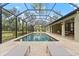 The stunning screened-in pool area features travertine tile, sun loungers, and a covered patio for outdoor entertaining at 2337 Legacy Ln, New Smyrna Beach, FL 32168