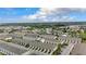 An aerial view of townhomes features well-manicured landscaping, neighborhood streets, and lush surrounding areas at 57 Bella Lago Cir, Port Orange, FL 32129