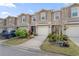 Inviting two-story townhomes featuring neutral paint, attached garages, and beautifully landscaped front yards at 57 Bella Lago Cir, Port Orange, FL 32129