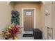 Charming front entrance with a neutral-colored door, potted plants, and a welcoming 'hello' doormat at 57 Bella Lago Cir, Port Orange, FL 32129