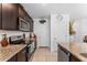 A kitchen features stainless steel appliances, granite countertops, and dark wood cabinets at 57 Bella Lago Cir, Port Orange, FL 32129