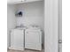 Bright laundry room with washer, dryer, and storage shelf at 57 Bella Lago Cir, Port Orange, FL 32129