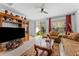 A cozy living room with a ceiling fan, tile flooring, comfortable seating, and a sliding glass door to the backyard at 57 Bella Lago Cir, Port Orange, FL 32129